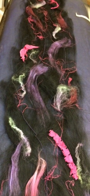 silk embellishments laid out on wool preparing to wet felt