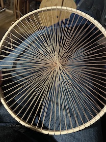 round wooden hoop loom warped with tan cotton crochet thread