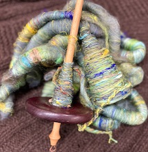 drop spindle with colorful wool and silk fibers